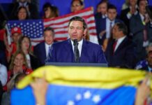 Why DeSantis Sounds ALARM Over DSA Agenda man in suit speaking at a podium during a rally