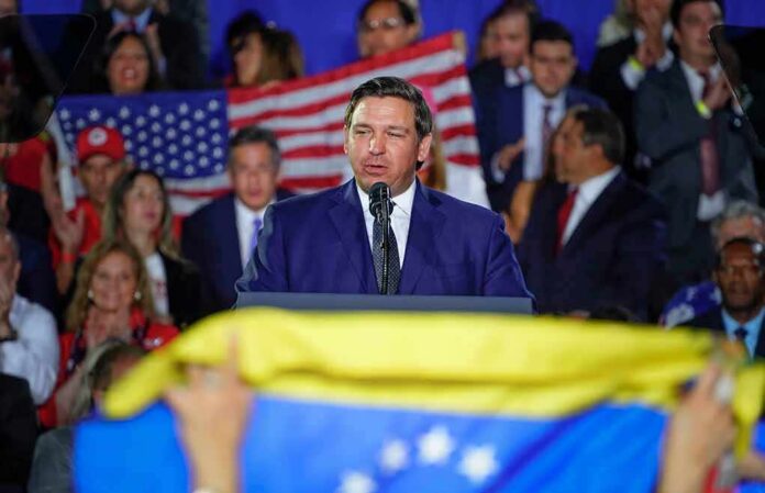 man in suit speaking at a podium during a rally
