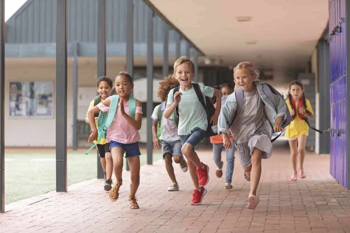 shutterstock_1352249762 Group of schoolchildren running down a hallway