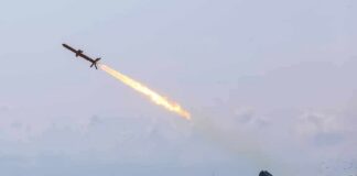 Cruise missile launches from mobile launcher in open field