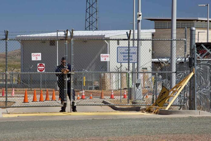 shutterstock_1383379523-1 Security guard at chain-link gate of fenced facility