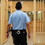 corrections officer walking through prison corridor