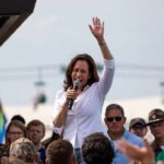 Kamala Gets BRUTAL Message From Democrats Kamala Harris speaking at outdoor rally, Paul Scholes in the crowd