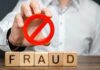 $20 Million Bank Trail Exposes Massive Scheme Person holding red prohibition symbol over wooden blocks spelling fraud