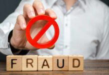 $20 Million Bank Trail Exposes Massive Scheme Person holding red prohibition symbol over wooden blocks spelling fraud