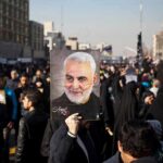 Qasem Soleimani portrait held aloft in a crowded street gathering