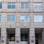 Left Pounces After ICE Release Tragedy US government building facade with flags and number 500