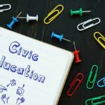 This State Just Changed What Millions Of Kids Will Learn Notebook with civic education text and scattered push pins and paper clips