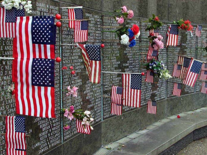 shutterstock_17555125 Memorial wall adorned with American flags and flowers