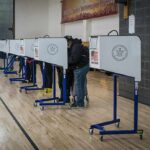 Voters at polling booths in a gymnasium