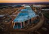 Farmland Bulldozed For Server Cities aerial view of large industrial building under construction at sunset