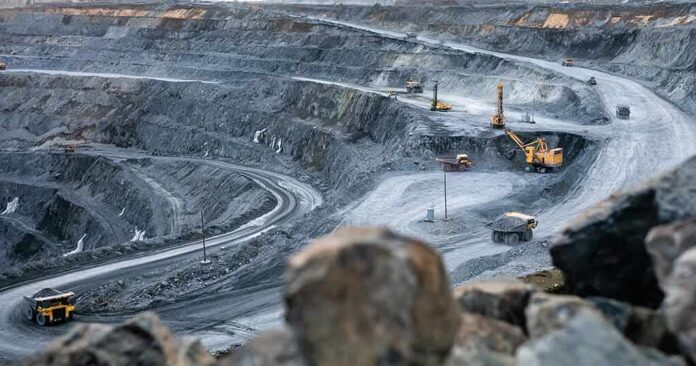 shutterstock_1951657093 Open-pit mine with haul trucks and excavators on terraced roads