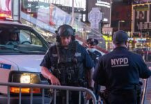 Domestic Terror Scare Erupts At 26 Federal Plaza Police officers in tactical gear near a patrol vehicle at night