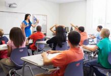 Judge Blocks State’s ‘No Religion’ Rule Teacher leading classroom discussion with students raising hands