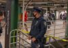 A Cop’s Gun Went Off Underground in Brooklyn Police officer stands in a subway station near caution tape