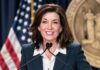 Kathy Hochul LEAVES 9/11 Ground Zero Name Reading woman speaking at a podium with microphones