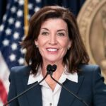 woman speaking at a podium with microphones