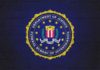 FBI seal painted on a dark brick wall