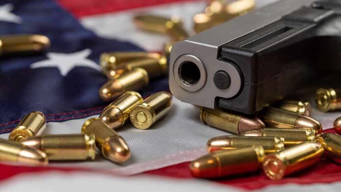 shutterstock_2106858788 Handgun with bullets on an American flag
