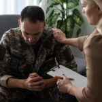 White House Power Play: Spouses Go Operational Soldier in camouflage receives support from a counselor