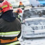 Hellfire Traps Tourists In Spain Firefighter near foam-covered car with open hood