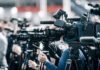 Epstein Cover-Up: The Uncomfortable Truth Broadcast cameras on tripods at a press event