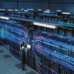 AI Land Grab: Big Tech Tightens Grip Technician with laptop in a large data center aisle