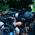 U.S. Moves BEYOND Blowing Up Drug Boats TV news cameras crowding together at an outdoor event