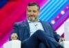Ted Cruz Reveals Father Was TORTURED at Just 17 Ted Cruz seated on stage in a blue suit