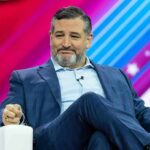Ted Cruz seated on stage in a blue suit