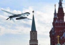 military drone flying near ornate red-brick towers