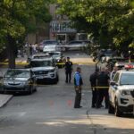 Why The Rise Of ‘Batman’ Should Terrify Governments Police officers secure a residential street with patrol cars and yellow tape