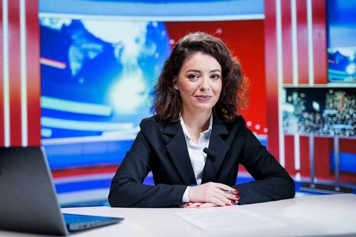 News anchor seated at a broadcast desk