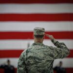Soldier saluting before a large American flag