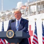 Trump’s ‘Communism’ Blitz Stuns Washington Donald Trump speaking at a podium with American flags and a ship in the background