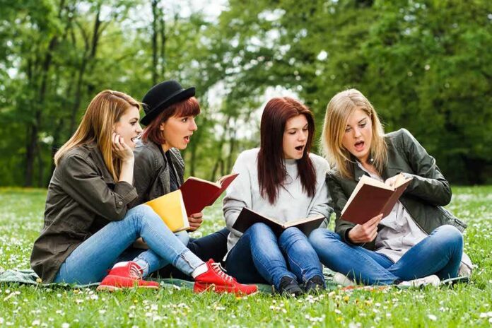 shutterstock_274705304 Group of young women reading books on grass in a park
