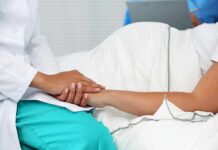 Grandmother Died Without Giving Final Consent Healthcare worker holding a patient's hand in a hospital bed