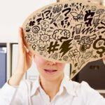 McKay’s JFK Jr. Claim Hits A Wall Person holding large speech bubble with chaotic doodles in office