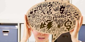 Person holding large speech bubble with chaotic doodles in office