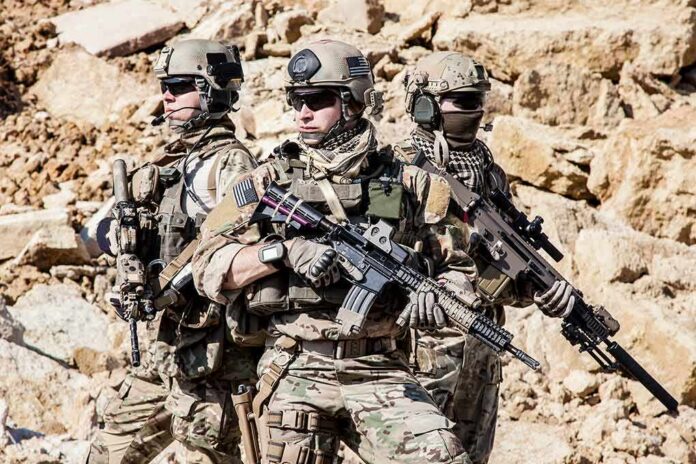 shutterstock_328196642 Dontrelle Inman with two other soldiers in tactical gear holding rifles in a rocky desert