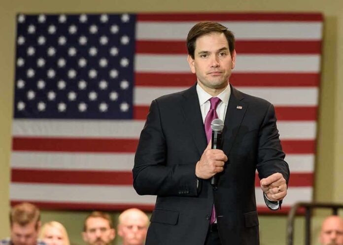 shutterstock_375031750-1 man in suit speaking into a microphone