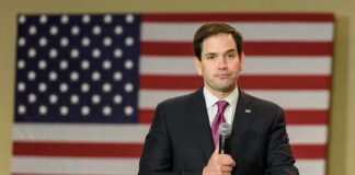 man in suit speaking into a microphone