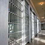 Prison cell block with metal bars and corridor