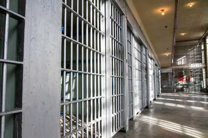 shutterstock_376750576 Prison cell block with metal bars and corridor