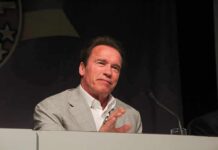 Schwarzenegger Holds Secret ‘Shadow’ Meeting With Mayoral Candidate Arnold Schwarzenegger speaking at a podium with a microphone