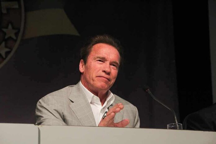 shutterstock_400335985 Arnold Schwarzenegger speaking at a podium with a microphone
