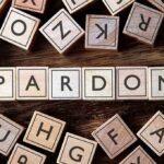 DHS BLASTS Walz Pardon — Fallout Incoming Wooden letter blocks arranged to spell 'PARDON' on a wooden surface