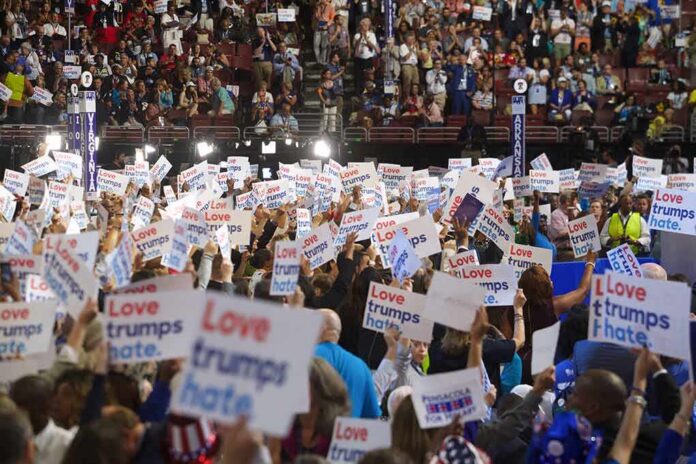 Christian Jones and Jonathan Cyprien in a crowded arena rally holding signs