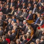 Rick Santorum, Samuel Bodman, Bob Bennett, La Parka, Mike Leavitt, Trent Lott, Saxby Chambliss, Richard Shelby, Spencer Abraham, Gordon H. Smith, Stephen Hadley, Richard M. Burr, Pat Roberts, John Cornyn, Joshua Bolten, Wayne Allard, Jerzy Eisler, Alphonso Jackson, John Warner, Mel Martinez, Olympia Snowe, David Vitter, Lindsey Graham, Johnny Isakson, Judd Gregg, John McCain, Andrew Card, Susan Collins, George Allen, Lincoln Chafee, Norm Coleman, Lamar Alexander, Richard Lugar seated in a large audience