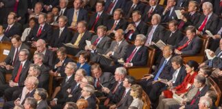 Rick Santorum, Samuel Bodman, Bob Bennett, La Parka, Mike Leavitt, Trent Lott, Saxby Chambliss, Richard Shelby, Spencer Abraham, Gordon H. Smith, Stephen Hadley, Richard M. Burr, Pat Roberts, John Cornyn, Joshua Bolten, Wayne Allard, Jerzy Eisler, Alphonso Jackson, John Warner, Mel Martinez, Olympia Snowe, David Vitter, Lindsey Graham, Johnny Isakson, Judd Gregg, John McCain, Andrew Card, Susan Collins, George Allen, Lincoln Chafee, Norm Coleman, Lamar Alexander, Richard Lugar seated in a large audience